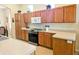 Modern kitchen with stainless steel appliances and wood cabinets at 9250 Alcott Way, Trinity, FL 34655