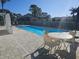 Community pool with patio furniture and shaded seating area at 9250 Alcott Way, Trinity, FL 34655