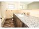 Bathroom with granite countertop, updated vanity, and wood-look floors at 9321 Mansard Ln, Port Richey, FL 34668