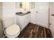 Updated bathroom with white vanity and wood-look floors at 9321 Mansard Ln, Port Richey, FL 34668