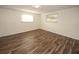 Bright bedroom with wood-look floors and large windows at 9321 Mansard Ln, Port Richey, FL 34668
