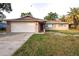 Ranch style home with attached garage and spacious lawn at 9321 Mansard Ln, Port Richey, FL 34668
