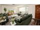 Virtually staged living room featuring green velvet sofas and a large TV at 9321 Mansard Ln, Port Richey, FL 34668