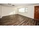 Living room featuring hardwood floors and a wood door at 9321 Mansard Ln, Port Richey, FL 34668