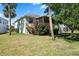 Landscaped backyard with a deck and screened porch at 1005 Mizzen Ct, Tarpon Springs, FL 34689