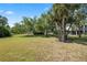 Large grassy backyard with mature trees at 1005 Mizzen Ct, Tarpon Springs, FL 34689