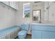 Light blue bathroom with toilet, sink, and built-in storage at 10239 Hoover St, Spring Hill, FL 34608