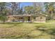 Stone house exterior with a covered porch and large yard at 10417 Joyce Dr, Brooksville, FL 34601