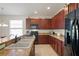 Well-equipped kitchen featuring dark wood cabinets and granite countertops at 11243 Merganser Way, New Port Richey, FL 34654