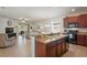Open kitchen with a breakfast bar, dark wood cabinets, and granite countertops at 11243 Merganser Way, New Port Richey, FL 34654