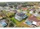 Aerial view of a home with solar panels, pool, and lush landscaping at 1230 Venetia Dr, Spring Hill, FL 34608