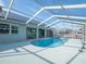 Inviting kidney-shaped pool with screened enclosure, providing shade and privacy at 1230 Venetia Dr, Spring Hill, FL 34608