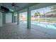 Relaxing pool area with screened enclosure, brick pavers, and lush landscaping at 1230 Venetia Dr, Spring Hill, FL 34608