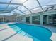 Enjoy this refreshing kidney-shaped pool with a screened enclosure at 1230 Venetia Dr, Spring Hill, FL 34608