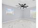 Spacious bedroom with two windows, ceiling fan, and marble floors at 13124 Lawrence St, Spring Hill, FL 34609