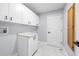 Bright laundry room featuring white cabinets and marble-look floors at 13124 Lawrence St, Spring Hill, FL 34609