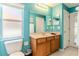 Light teal bathroom with wood vanity and a separate toilet area at 13793 Dunwoody Dr, Spring Hill, FL 34609