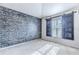 Bright bedroom with brick accent wall and barn door window coverings at 13793 Dunwoody Dr, Spring Hill, FL 34609