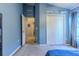 Bedroom with blue walls, double doors to closet, and access to hallway at 13793 Dunwoody Dr, Spring Hill, FL 34609