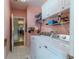 Bright laundry room with washer, dryer, and storage shelving at 13793 Dunwoody Dr, Spring Hill, FL 34609