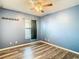 Bedroom with blue walls, wood floors and window at 14549 Wake Robin Dr, Brooksville, FL 34604