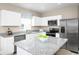 Modern kitchen with white cabinets, granite countertops, and stainless steel appliances at 17104 6Th E Ter, Bradenton, FL 34212