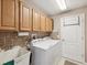 Bright laundry room with washer, dryer, cabinets, and utility sink at 18803 Rolling Hills Loop, Hudson, FL 34667