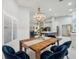 Open concept dining room with wooden table and blue chairs, adjacent to kitchen at 19617 Ellendale Dr, Land O Lakes, FL 34638