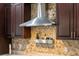 Kitchen detail showing stainless steel range hood and hexagon tile backsplash at 3110 Lema Dr, Spring Hill, FL 34609