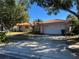 Spanish style home with tile roof, attached garage, and well-manicured lawn at 3151 Carlos Dr, Dunedin, FL 34698