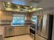 Kitchen with stainless steel appliances and a view of the backyard pool at 3151 Carlos Dr, Dunedin, FL 34698
