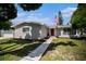 One-story house featuring gray exterior, landscaped yard, and walkway at 4602 W Hawthorne Rd, Tampa, FL 33611