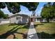 Gray exterior, manicured lawn, and inviting walkway leading to the entrance at 4602 W Hawthorne Rd, Tampa, FL 33611