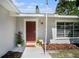 Inviting front entrance with a dark red door and welcome mat at 4602 W Hawthorne Rd, Tampa, FL 33611