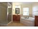 Spa-like bathroom featuring a corner tub, walk-in shower, and dual sinks at 4634 Mapletree Loop, Wesley Chapel, FL 33544