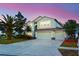 Two-story house with a three-car garage and landscaped lawn at 4634 Mapletree Loop, Wesley Chapel, FL 33544