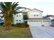 Two-story house with a two-car garage and manicured lawn at 4634 Mapletree Loop, Wesley Chapel, FL 33544