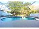 Relaxing kidney-shaped pool with a screened enclosure at 4634 Mapletree Loop, Wesley Chapel, FL 33544