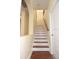 Simple white and wood staircase leading to the upper level at 4634 Mapletree Loop, Wesley Chapel, FL 33544