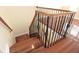 Elegant staircase with wrought iron balusters and hardwood flooring at 4634 Mapletree Loop, Wesley Chapel, FL 33544