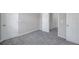 Neutral-toned bedroom with gray carpeting and multiple doors at 5742 Meadowlane St, New Port Richey, FL 34652