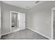 Bright bedroom with grey carpet, en-suite bathroom, and double door closet at 5742 Meadowlane St, New Port Richey, FL 34652