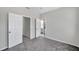 Well-lit bedroom featuring gray carpet and multiple entrances at 5742 Meadowlane St, New Port Richey, FL 34652