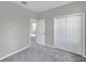 Bedroom with grey carpet, double door closet, and adjacent bathroom at 5742 Meadowlane St, New Port Richey, FL 34652