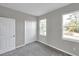 Grey bedroom with carpet, double door closet, and two windows at 5742 Meadowlane St, New Port Richey, FL 34652