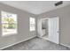 Spacious bedroom with grey carpet, en-suite bathroom, and two windows at 5742 Meadowlane St, New Port Richey, FL 34652