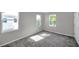 Bright bedroom with gray carpeting and multiple windows at 5742 Meadowlane St, New Port Richey, FL 34652