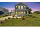 Two-story craftsman home with gray siding and yellow door at 5742 Meadowlane St, New Port Richey, FL 34652