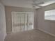 Bright bedroom with ceiling fan, window blinds, and neutral carpeting at 7129 Beachdale Ct, Port Richey, FL 34668
