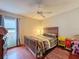 Bedroom with wood bed frame, window, and ceiling fan at 8015 Pequena Dr, Port Richey, FL 34668